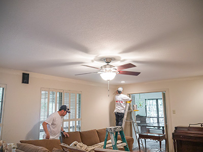 two painters painting drywall